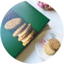 Plate of cookies sits beside an open book with cookie images on a green background, creating a cozy, inviting atmosphere.
