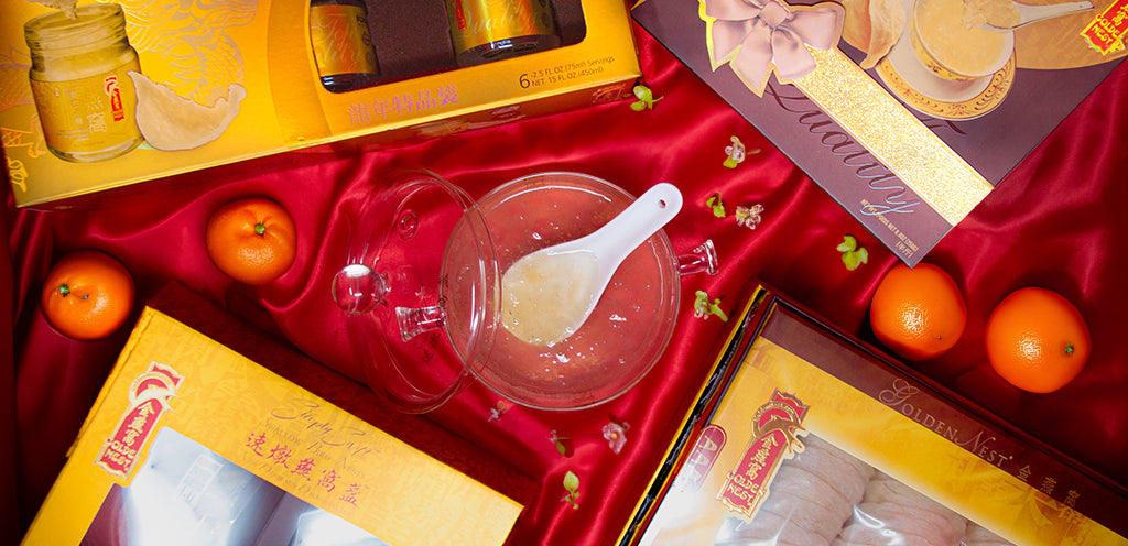 Image of Golden Nest limited-edition dragon box a bowl of cooked edible birds nest and mandarins on a red silk cloth.